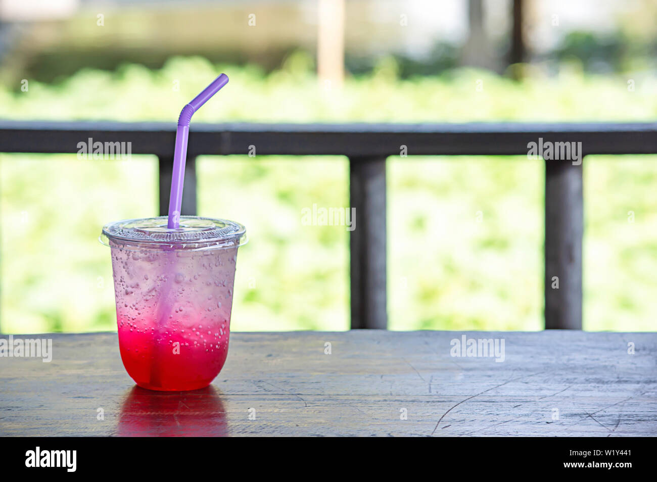 Jus de fruits rouges avec de la glace dans un verre en plastique sur la table Banque D'Images