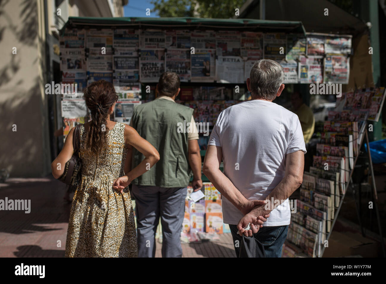 04 juillet 2019, de la Grèce, Athènes : passants lire la une des journaux dans un kiosque. Le dimanche les électeurs grecs sont susceptibles de rejeter les partis extrêmes dans les élections parlementaires. Selon les sondages, l'extrême-droite l'Aube dorée et le parti communiste KKE forte une fois n'atteignent même pas 4 pour cent. Le parti populiste de droite, de l'Anel qui a siégé en tant que petit partenaire de coalition dans le gouvernement jusqu'au début de cette année, ne prend même pas office. Contrairement à la tendance européenne, les Grecs en faveur de la parties. (Dpa 'No cross pour les populistes : pari probablement grecs Banque D'Images