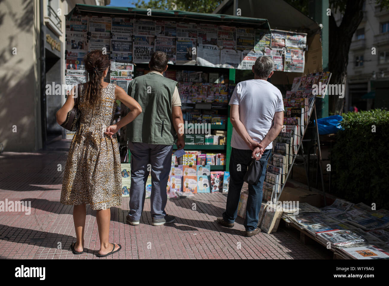 04 juillet 2019, de la Grèce, Athènes : passants lire la une des journaux dans un kiosque. Le dimanche les électeurs grecs sont susceptibles de rejeter les partis extrêmes dans les élections parlementaires. Selon les sondages, l'extrême-droite l'Aube dorée et le parti communiste KKE forte une fois n'atteignent même pas 4 pour cent. Le parti populiste de droite, de l'Anel qui a siégé en tant que petit partenaire de coalition dans le gouvernement jusqu'au début de cette année, ne prend même pas office. Contrairement à la tendance européenne, les Grecs en faveur de la parties. (Dpa 'No cross pour les populistes : pari probablement grecs Banque D'Images