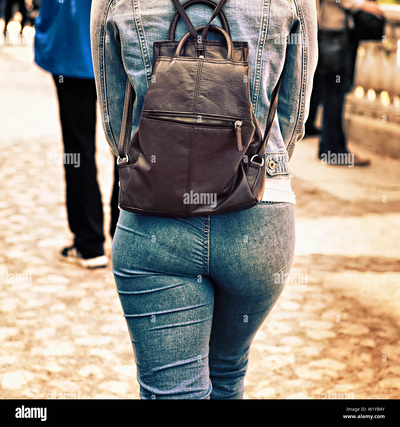 Jeune fille dans un costume en jean avec un sac sur ses épaules Banque D'Images