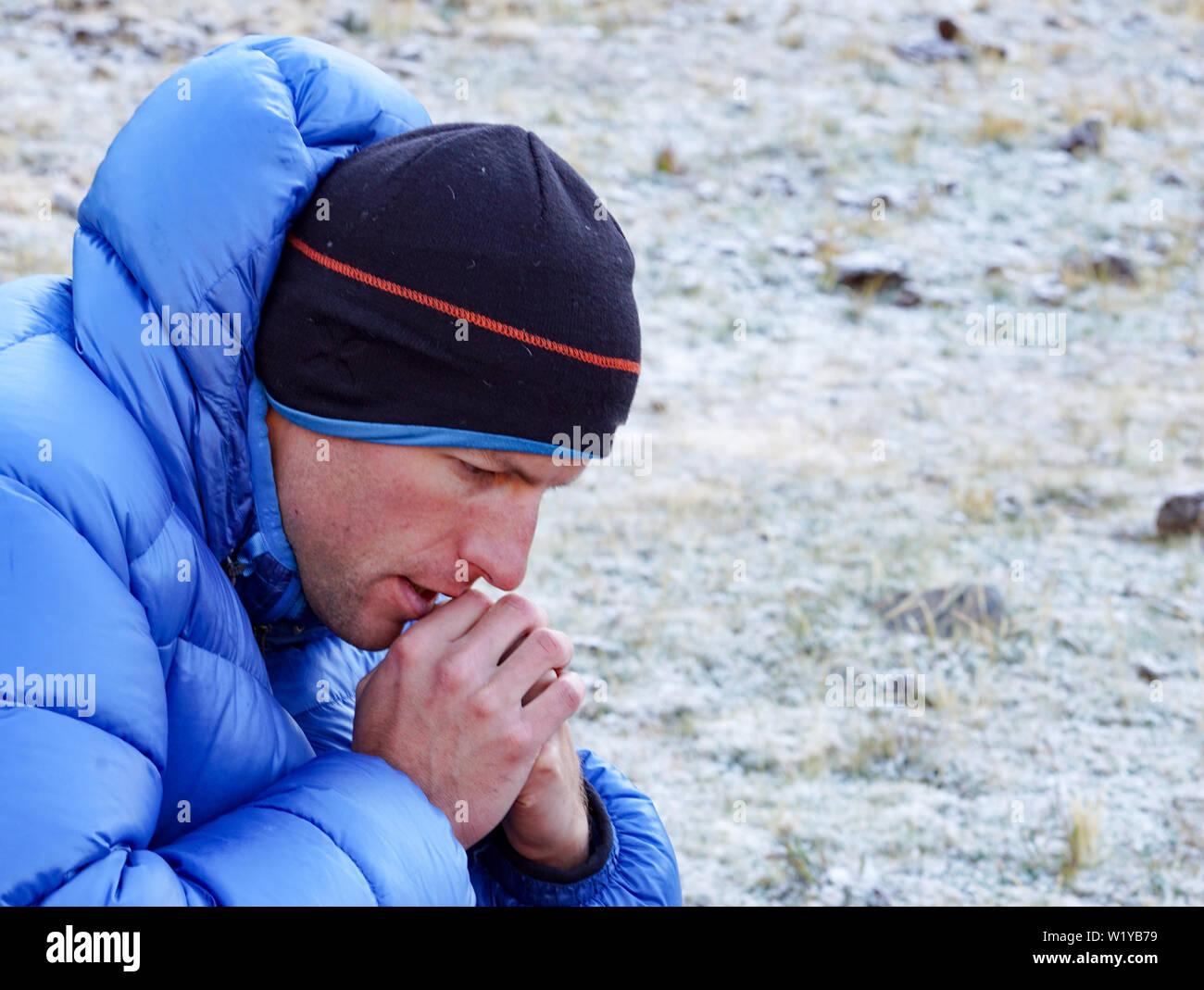 Gros plan d'une alpiniste pensif et concentré dans un épais Down jacket perdu dans ses pensées et à l'avant Banque D'Images