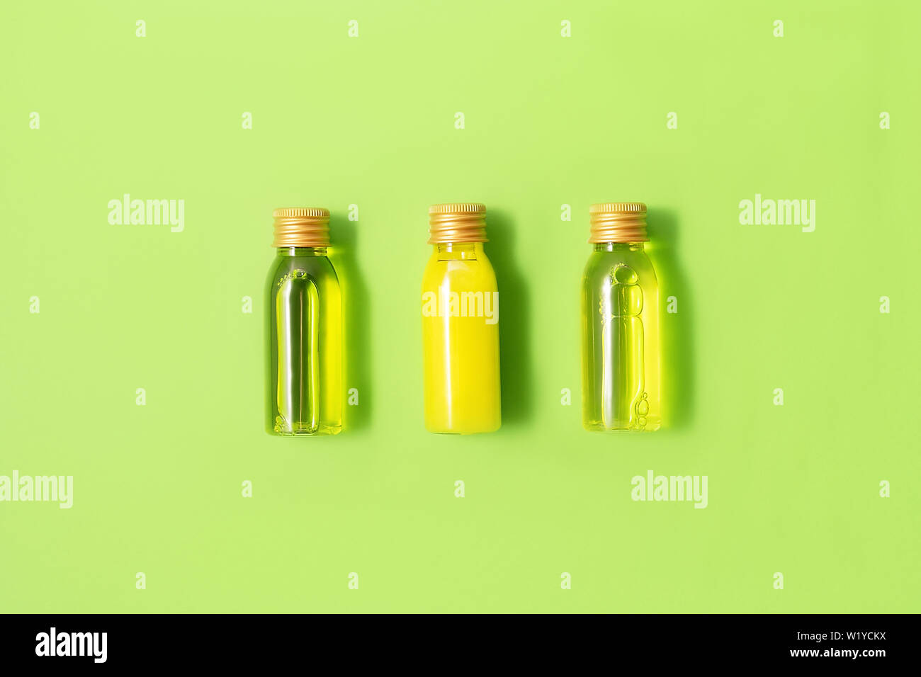 Mise à plat de trois petites bouteilles de maquettes avec spa produits cosmétiques sur fond vert. Femmes beauté et salon de beauté concept. Eco concept. Banque D'Images