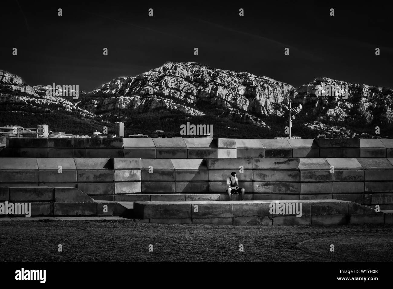 Marseille, France, juin 2018, l'homme assis sur une vague de béton sur la plage du Prado disjoncteur Banque D'Images