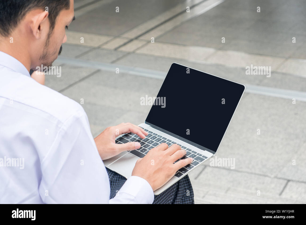 Young businessman working on laptop à l'extérieur Banque D'Images