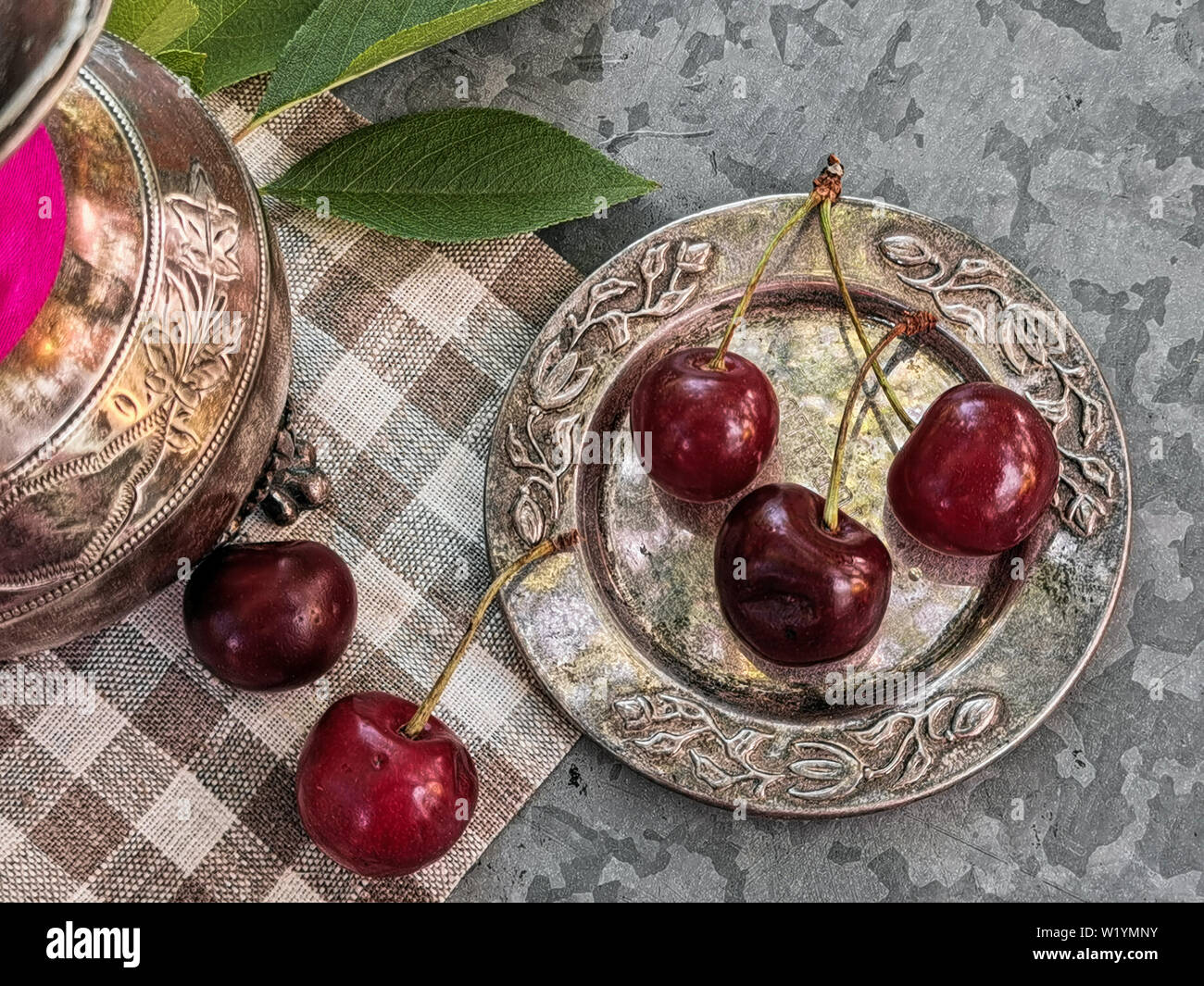 Belle cerise sur le tableau et sur la soucoupe. Des cerises et des noyaux de cerise, de puits sur une plaque Banque D'Images