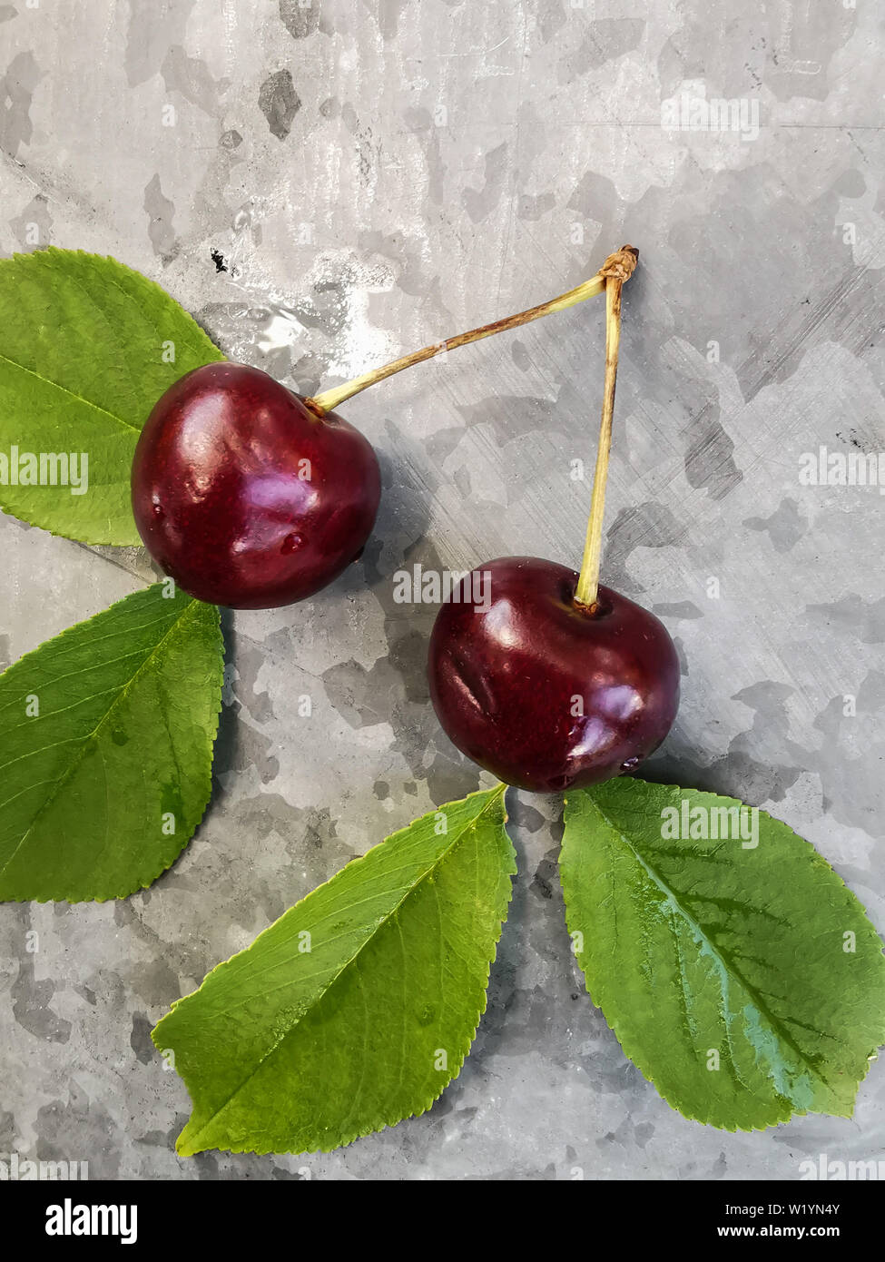 Belle cerise sur le tableau et sur la soucoupe. Des cerises et des noyaux de cerise, de puits sur une plaque Banque D'Images