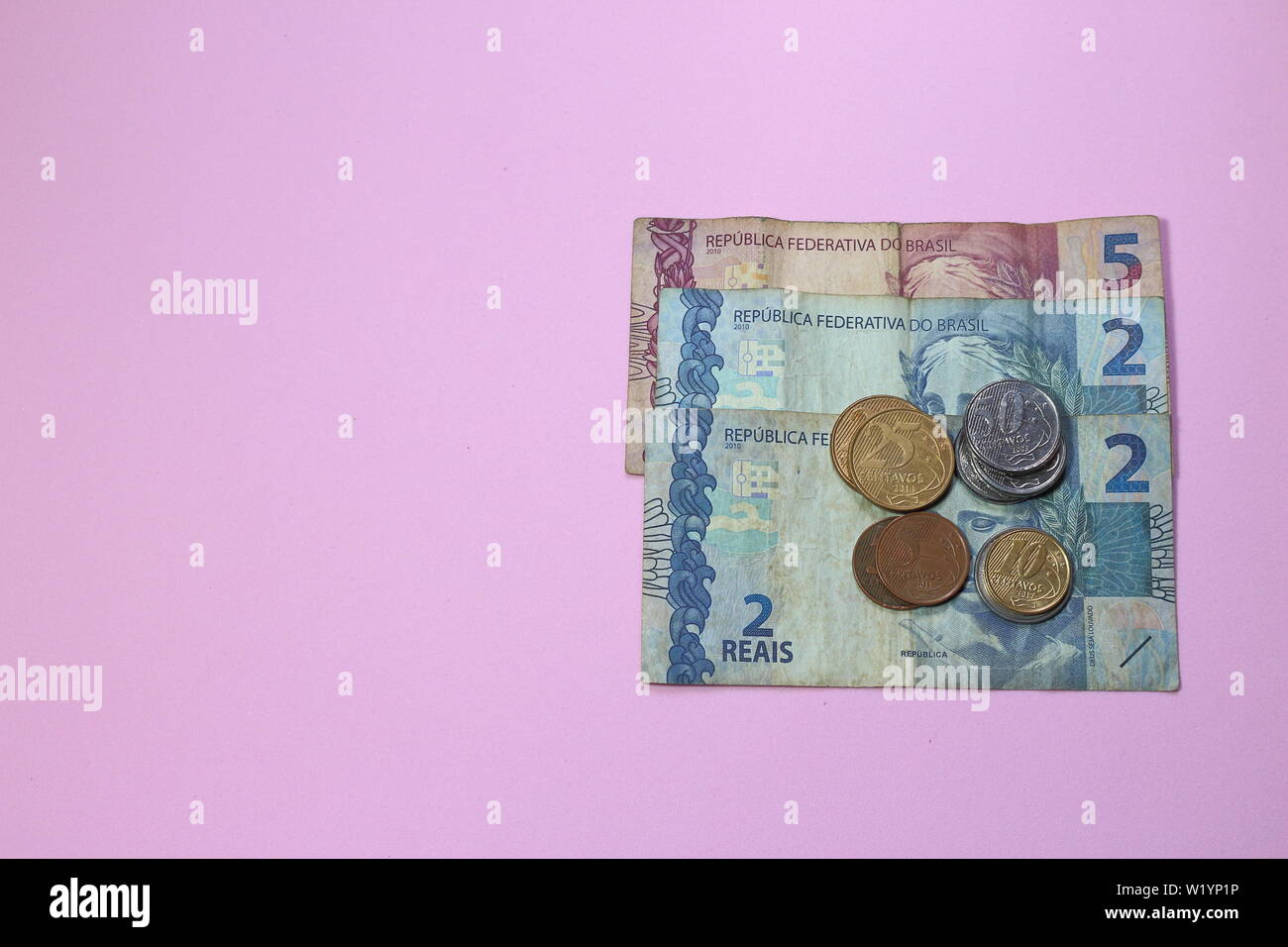 Pile de faible valeur de l'argent brésilien sur fond rose avec copie espace pour le texte. L'argent d'économie au Brésil est difficile pour la génération du nouveau millénaire. La manière de procéder ? Banque D'Images