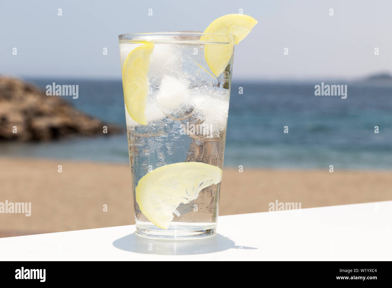 Grand verre d'eau avec de la glace et de tranches de citron Banque D'Images
