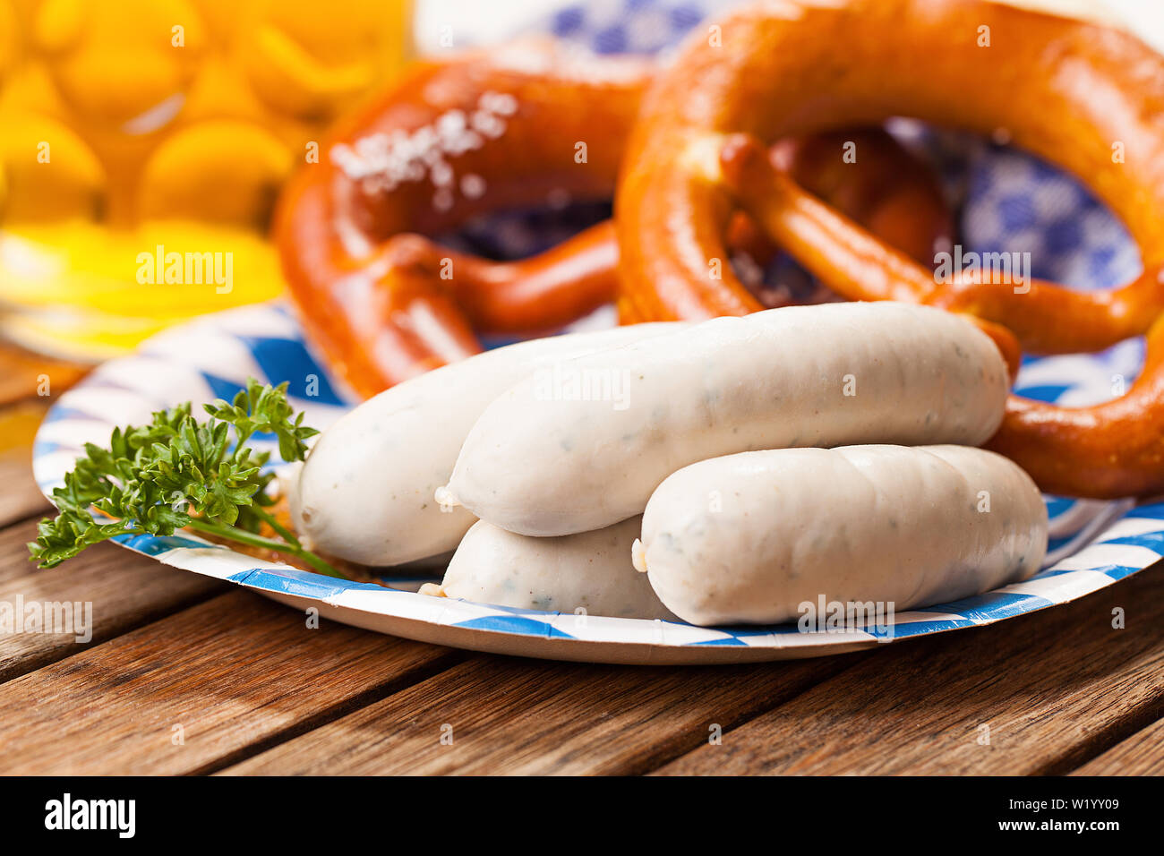 Bretzel et saucisse blanche sur des plats de style bavarois sur table en bois Banque D'Images