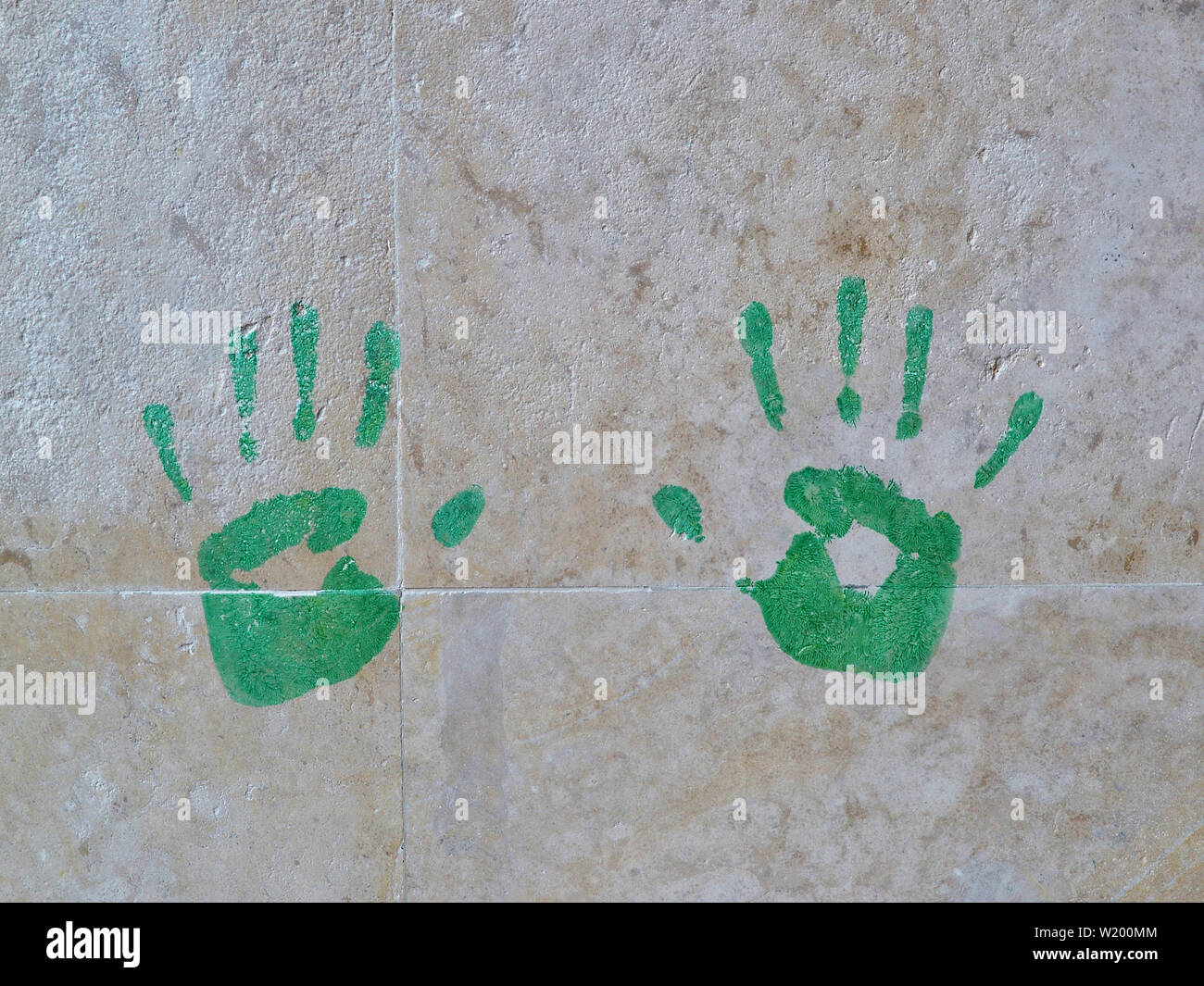 Des empreintes de main de couleur verte sur le mur de carreaux en marbre close-up. Banque D'Images