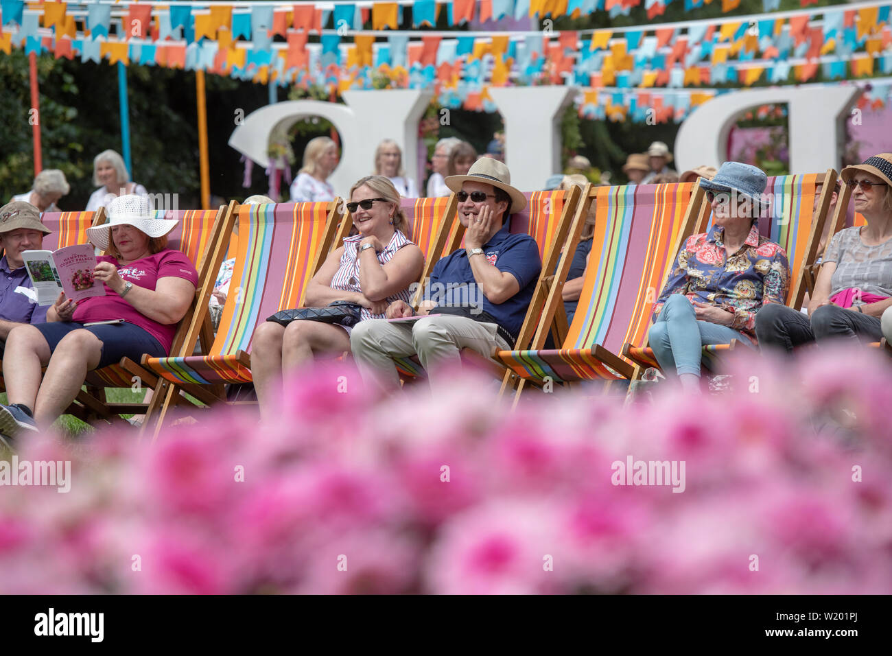 Les gens assis dans des transats jouissant de la musique dans le kiosque à RHS Hampton Court Flower Show 2019. Le Palais de Hampton Court, East Molesey, Surrey, Englan Banque D'Images