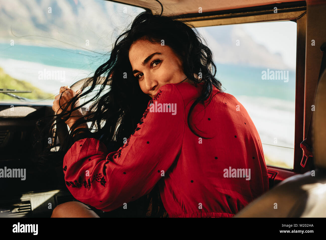 Vue arrière du jeune femme au volant d'une voiture. Les femmes de race blanche de partir en voyage. Banque D'Images