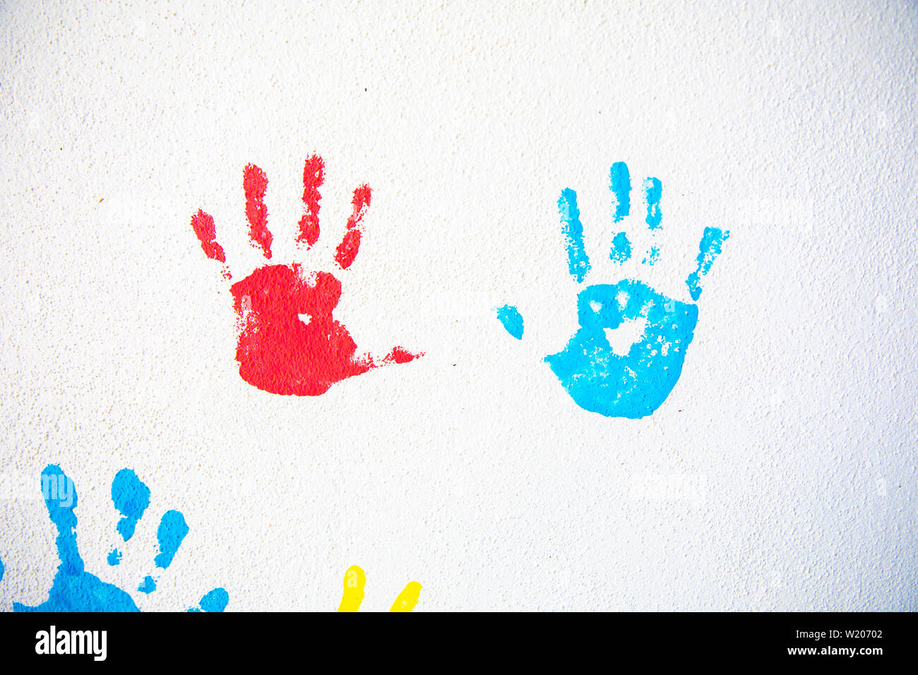 Colorful hand imprime des mains isolé sur fond de mur blanc. Les empreintes de mains sur le mur de l'école Banque D'Images