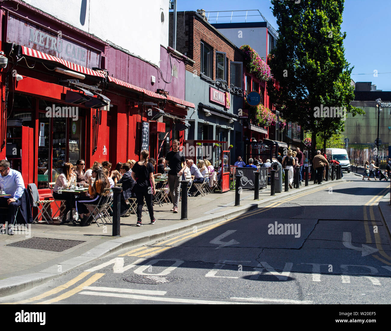 Dubliners profitant de la météo d'été manger au restaurant dans une rue de la ville. Banque D'Images