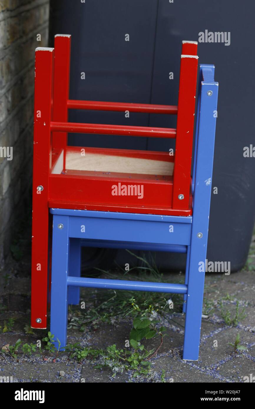 Image en couleur montrant deux chaises en bois similaire, l'un peint en rouge et l'autre peint en bleu empilés sur eux d'une manière ordonnée Banque D'Images