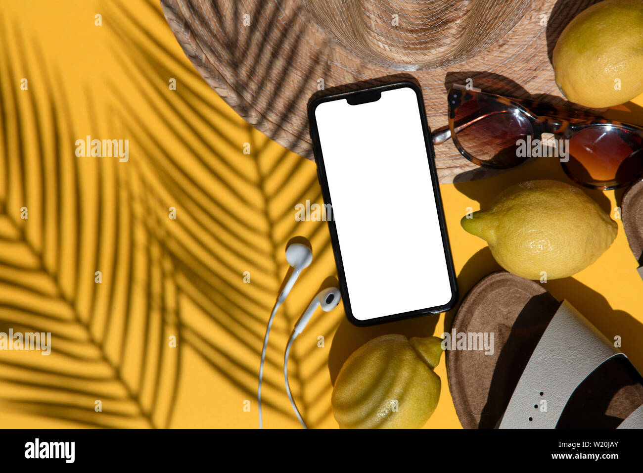 Composition d'été. Smartphone blanc avec accessoires d'été et l'ombre de palmiers Banque D'Images