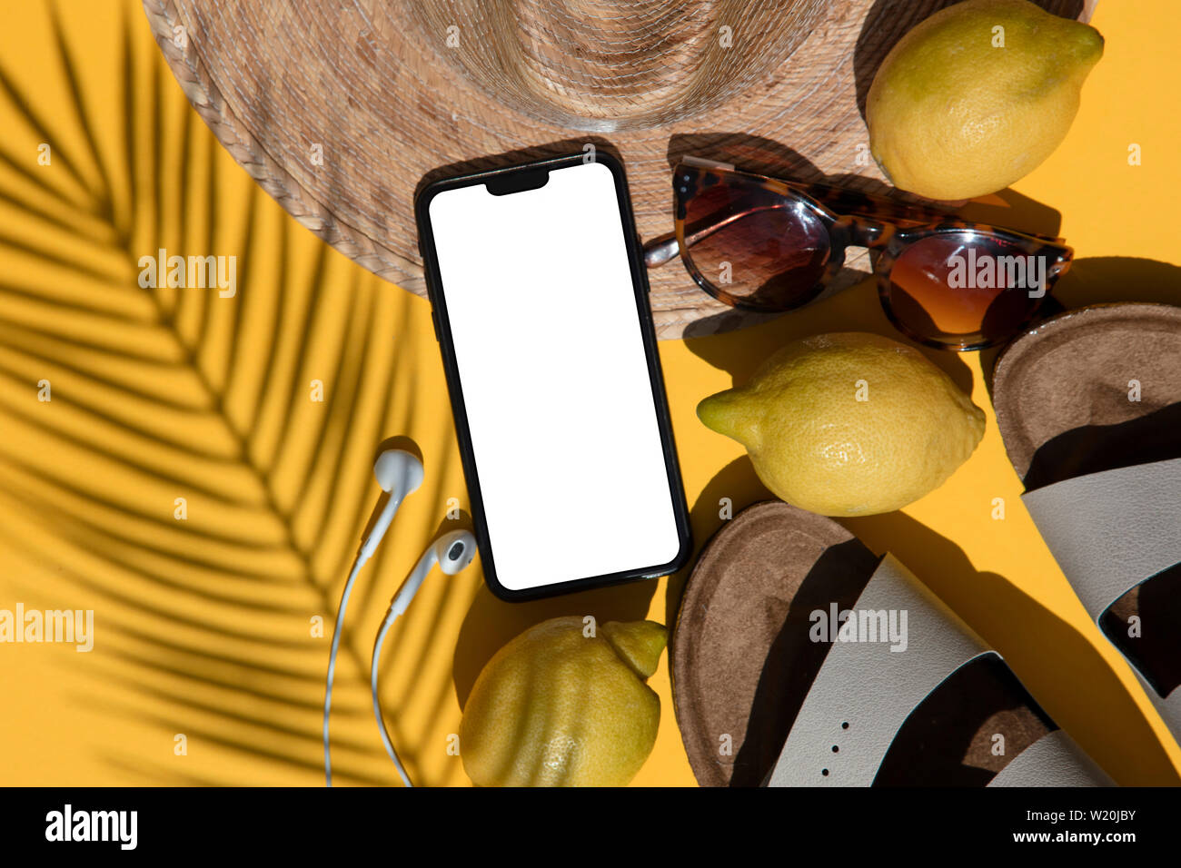 Composition d'été. Smartphone blanc avec accessoires d'été et l'ombre de palmiers Banque D'Images