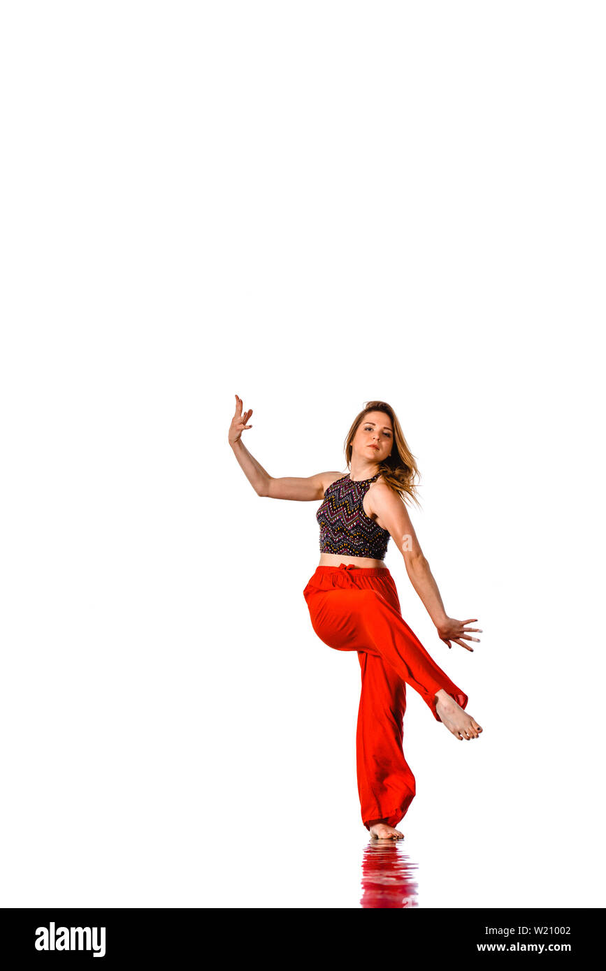 Femme dans le street style vêtements danse avec propagation d'armes et a  ressuscité. La pleine longueur du corps portrait isolé sur mur blanc Photo  Stock - Alamy