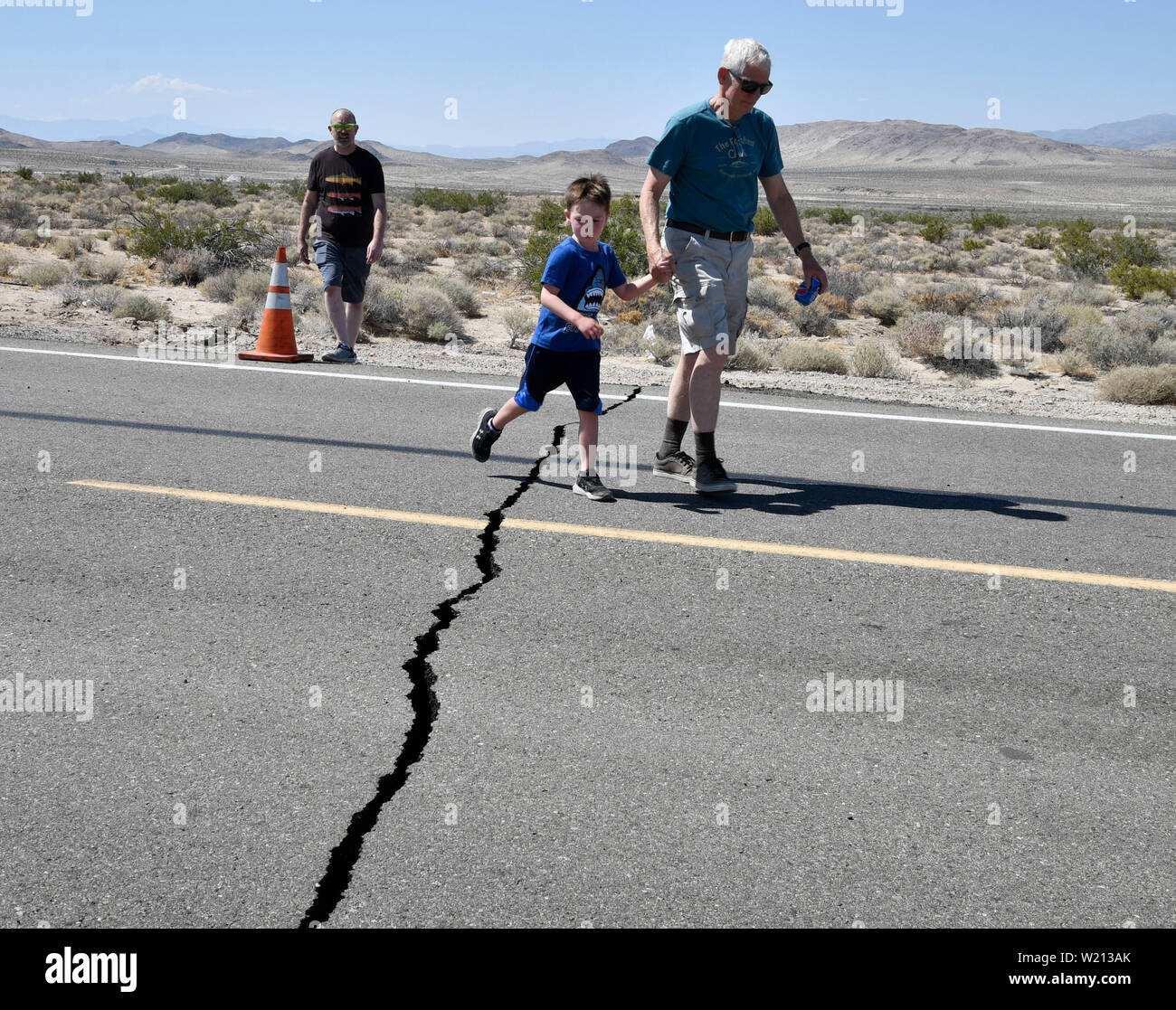 Fil, le sud de la Californie, USA. 4 juillet 2019. Deux personnes traverser une fissure sur la route de l'autoroute 178 à l'est de Honfleur après un séisme de magnitude 6,4 jeudi matin dans le désert de Mojave, la vallée sans sur la quatrième de juillet. Credit : ZUMA Press, Inc./Alamy Live News Banque D'Images