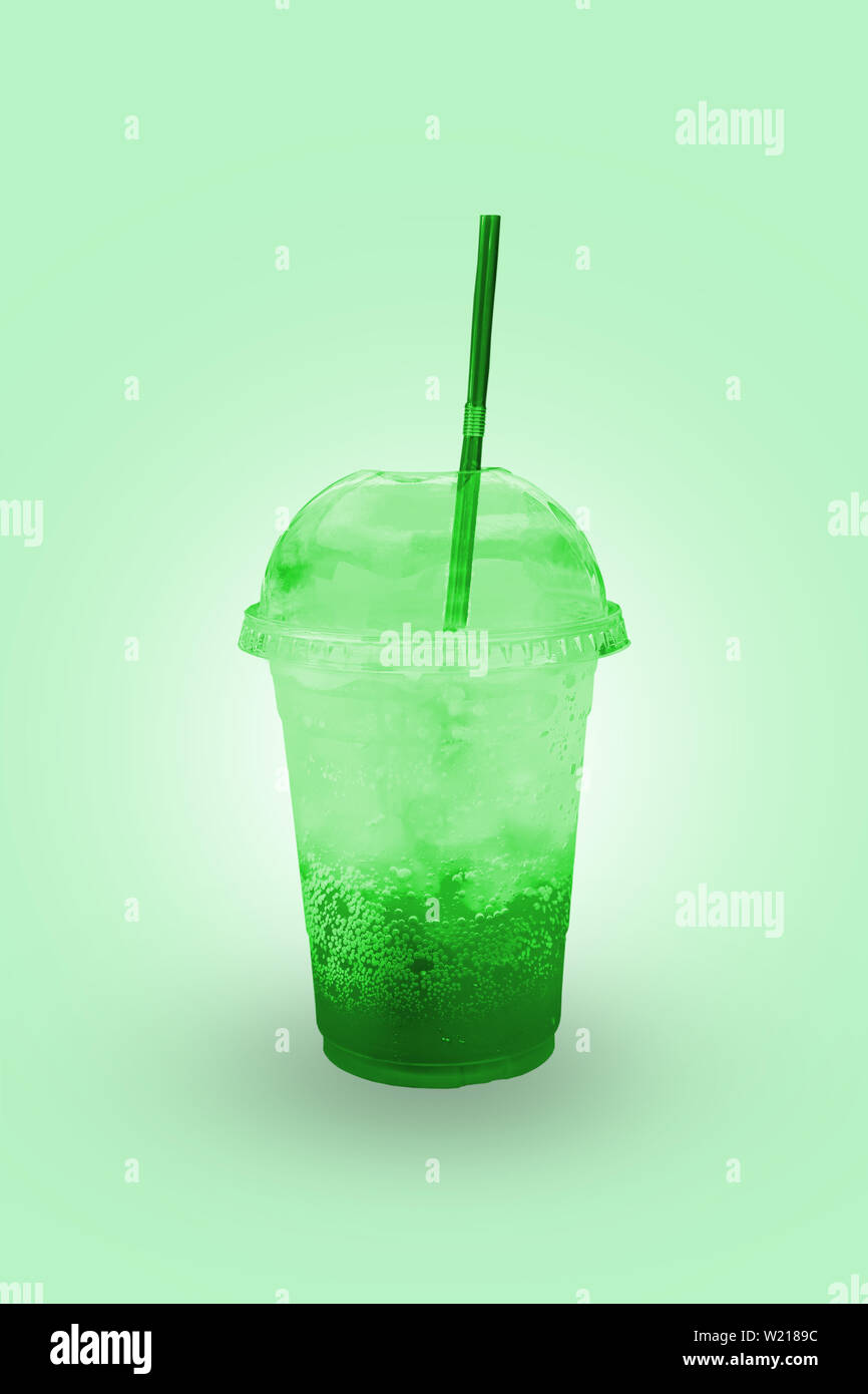 Jus vert avec de la glace dans un verre en plastique avec chemin de détourage. Banque D'Images