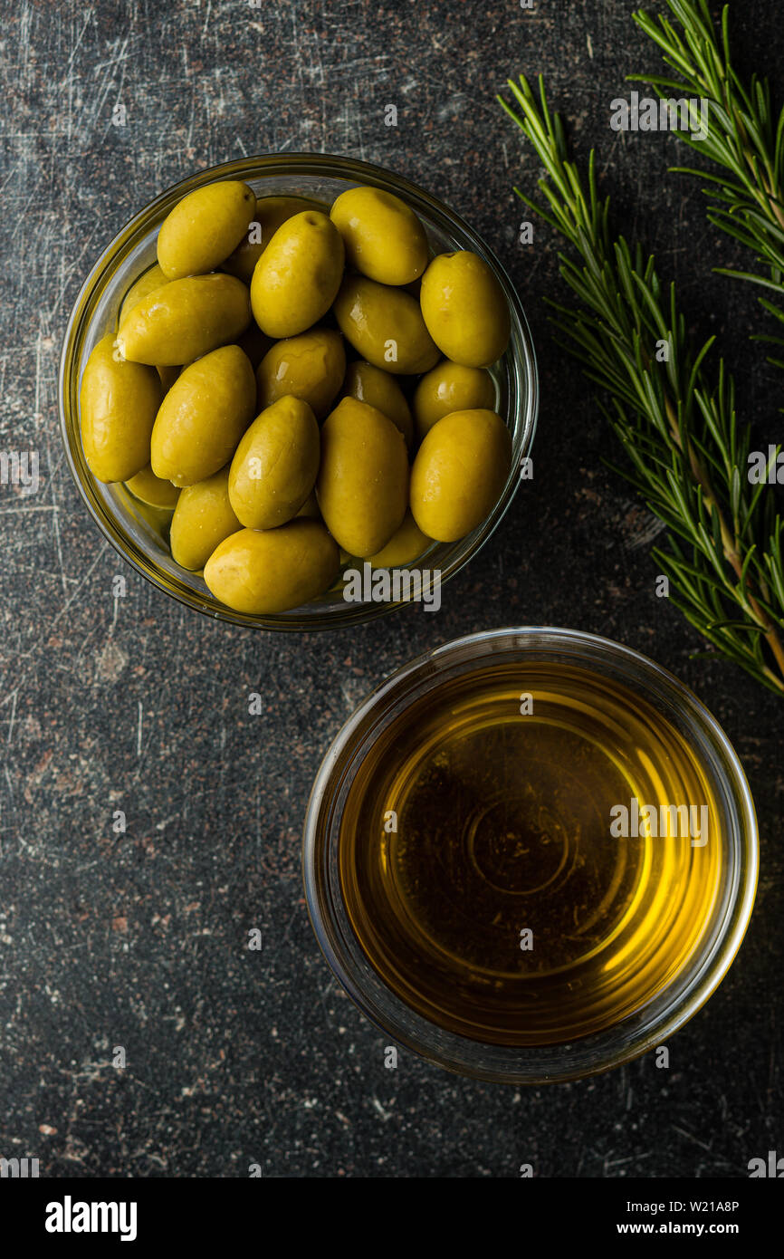 Green olives et huile d'olive dans un bol en verre. L' affichage. Banque D'Images