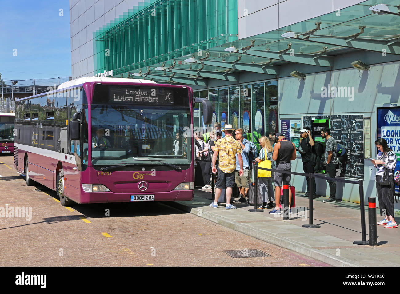 L'aéroport de Luton, Londres. Les passagers arrivant à l'aéroport de Luton Parkway Gare attendre à bord de la navette pour le terminal de l'aéroport. Banque D'Images