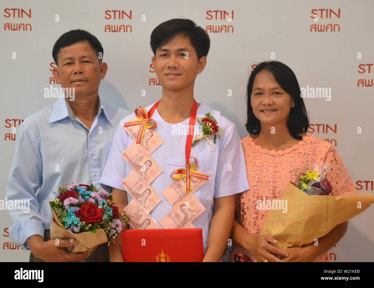 Un jeune élève porte une guirlande faite de l'argent des billets, tandis que les étudiants thaïlandais et leurs familles à l'Srisavarindhira Institut de la Croix-Rouge thaïlandaise (soins infirmiers TRCN) à Bangkok, Thaïlande, célébrer le progrès avec leurs études le 5 juillet 2019. TRCN, fondée en 1914, est l'une des plus anciennes et des plus importantes écoles de soins infirmiers en Thaïlande. Chaque année, il s'inscrit plus de 1 000 étudiants en soins infirmiers. Banque D'Images