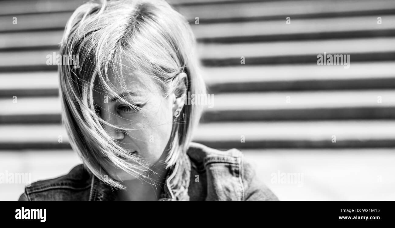 Portrait d'une fille aux cheveux courts. Blonde dans la ville. La photographie en noir et blanc. Banque D'Images