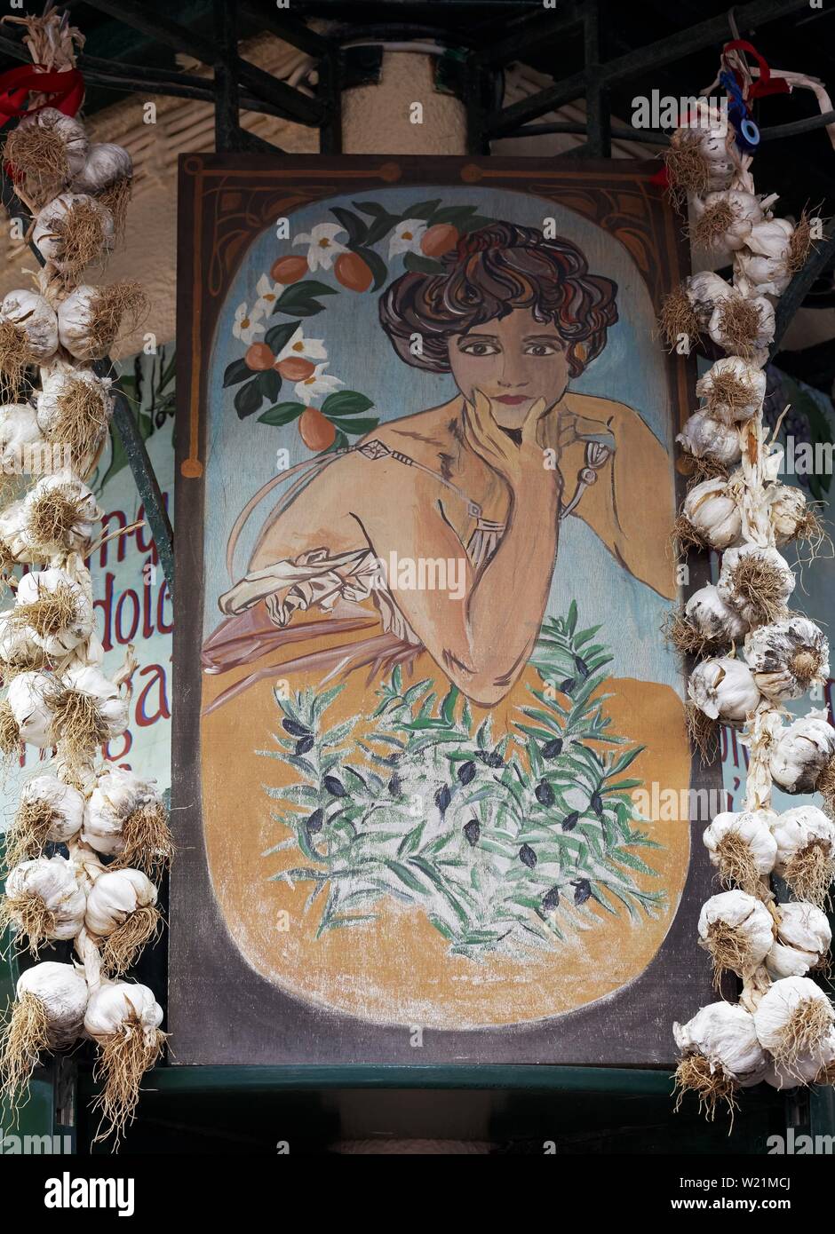 Dame figure avec des olives, la publicité peinte signe entre l'ail tresses, épicerie dans la vieille ville, la ville de Corfou, île de Corfou, îles Ioniennes Banque D'Images