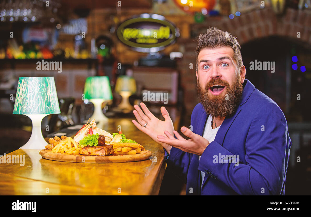 Profitez de repas. Tricher repas. Hipster faim manger pub aliments frits. Restaurant client. Costume officiel Hipster s'asseoir au comptoir du bar. L'homme a reçu de pommes de terre frites repas avec les bâtonnets de poisson viande. Délicieux repas. Banque D'Images