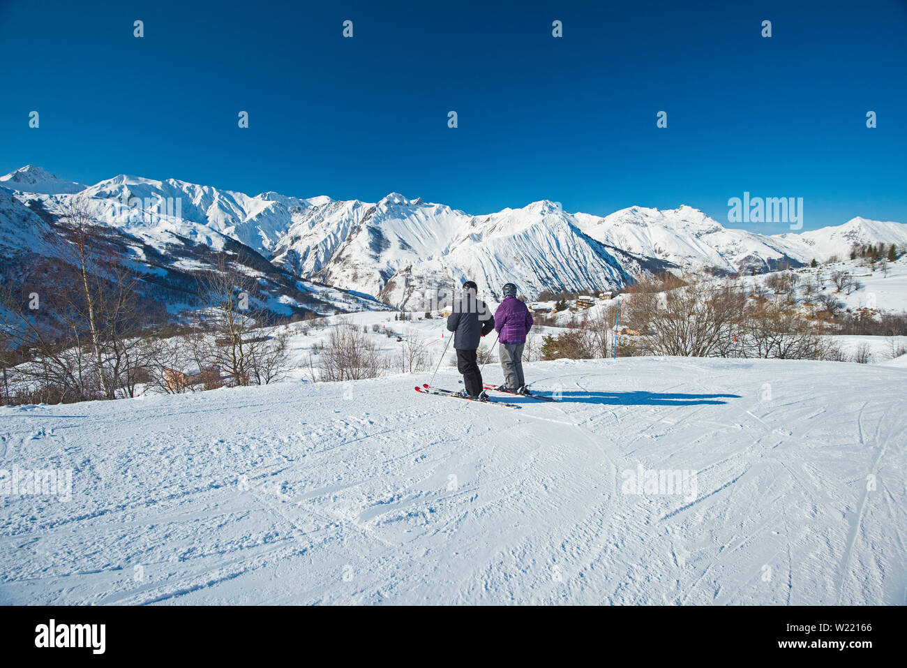 Paysage panoramique avec vue sur la vallée les skieurs de descendre une piste de ski alpin en hiver mountain resort Banque D'Images