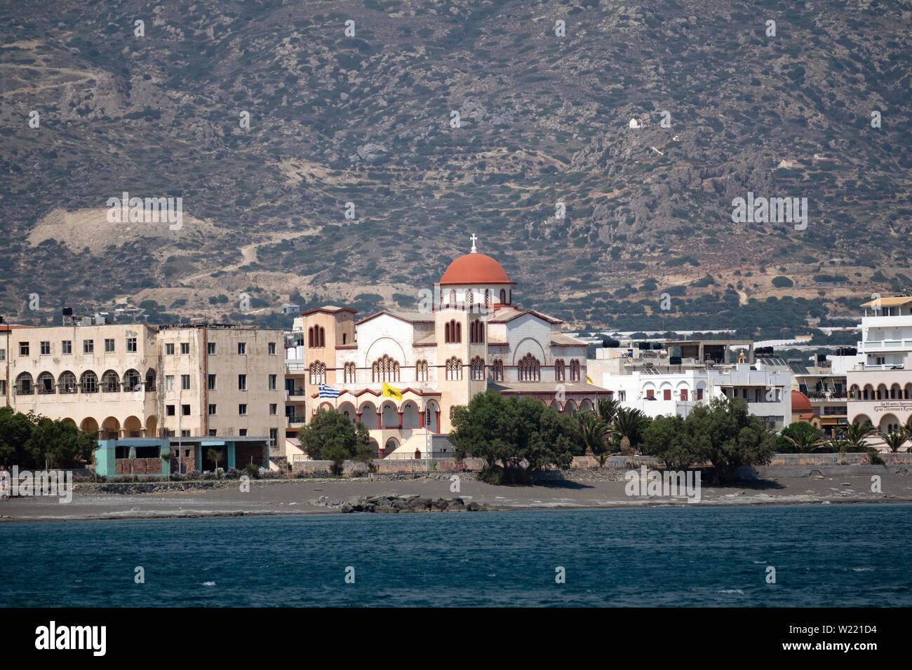 Ierapetra, Crete, Grèce. Juin 2019. Le sud de la ville côtière de Ierapetra et l'église d'Agia Fotini avec un décor de montagnes Banque D'Images