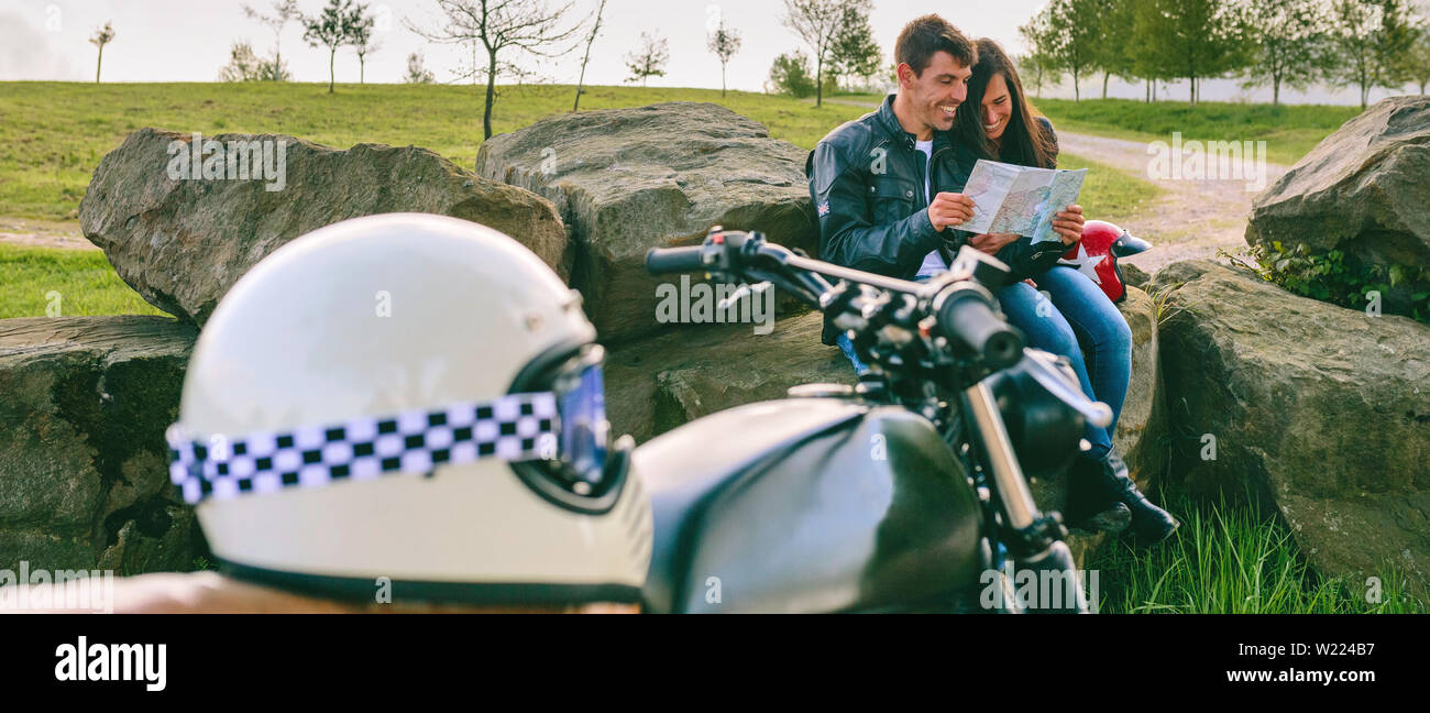Couple assis regardant une carte avec motorcycle Banque D'Images