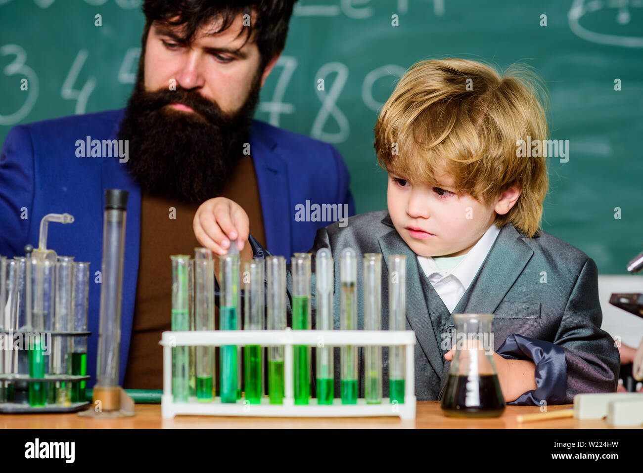 Homme enseignant avec petit garçon. Laboratoire de sciences biologie. père et fils à l'école. L'apprentissage de la chimie en laboratoire d'école. Retour à l'école. La recherche scientifique et des expériences. Je le zinc je t'aime bien. Banque D'Images