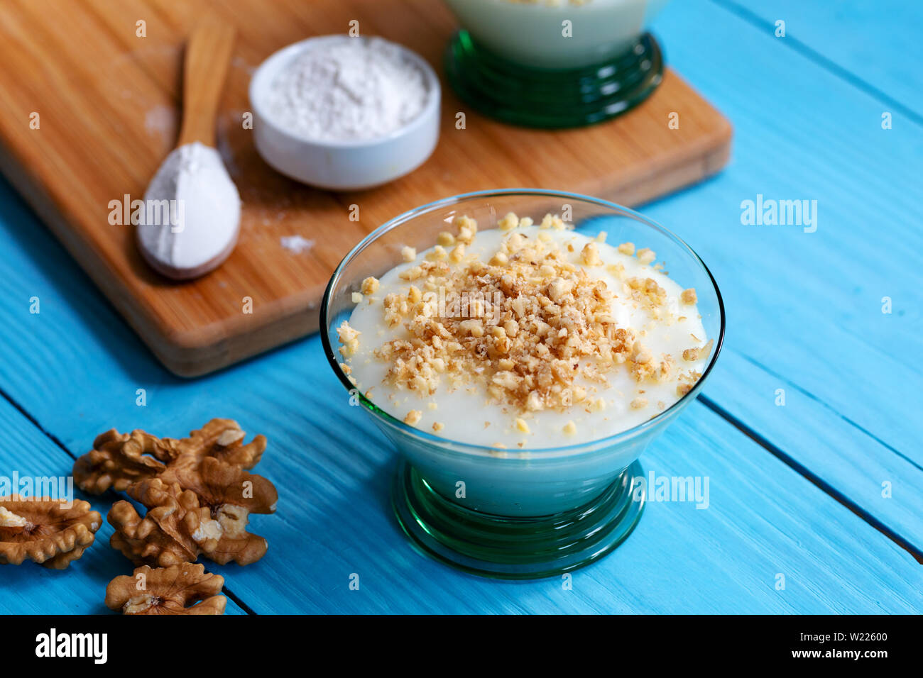 Crème anglaise faite maison avec le noyer, Turkish muhallebi sur fond de bois Banque D'Images