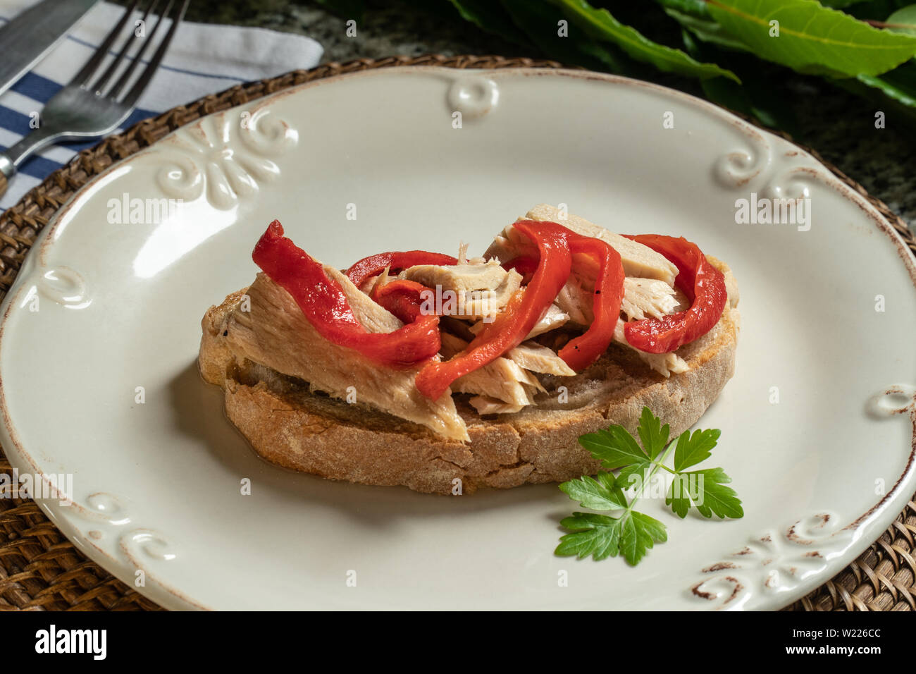 Délicieux sandwich ouvert ou toast avec du thon et des poivrons rouges sur la plaque. La cuisine méditerranéenne Banque D'Images