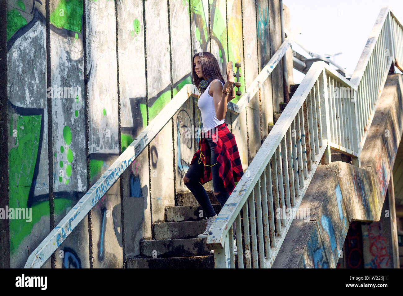 Jeune fille woman holding skateboard en plein air, mode de vie urbain. Banque D'Images