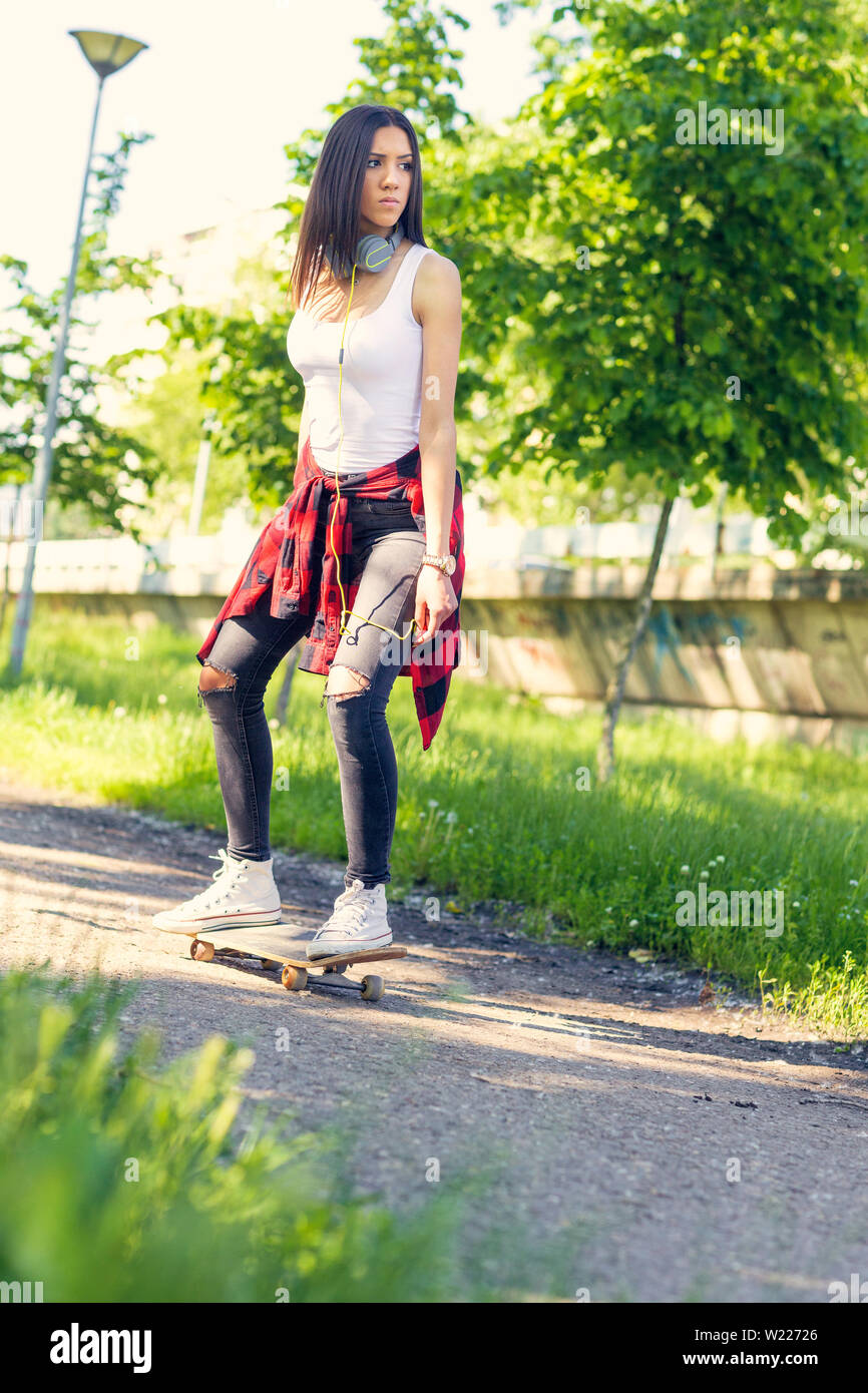 Adolescente urbaine équitation skateboards sur street Banque D'Images
