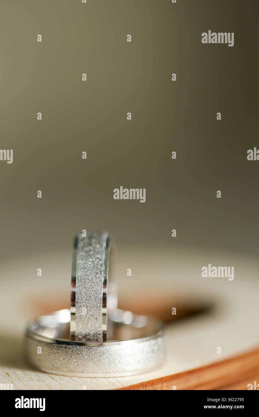 Deux anneaux de mariage sur la caisse en bois en forme de coeur. Close up plan macro sur bagues argent Banque D'Images