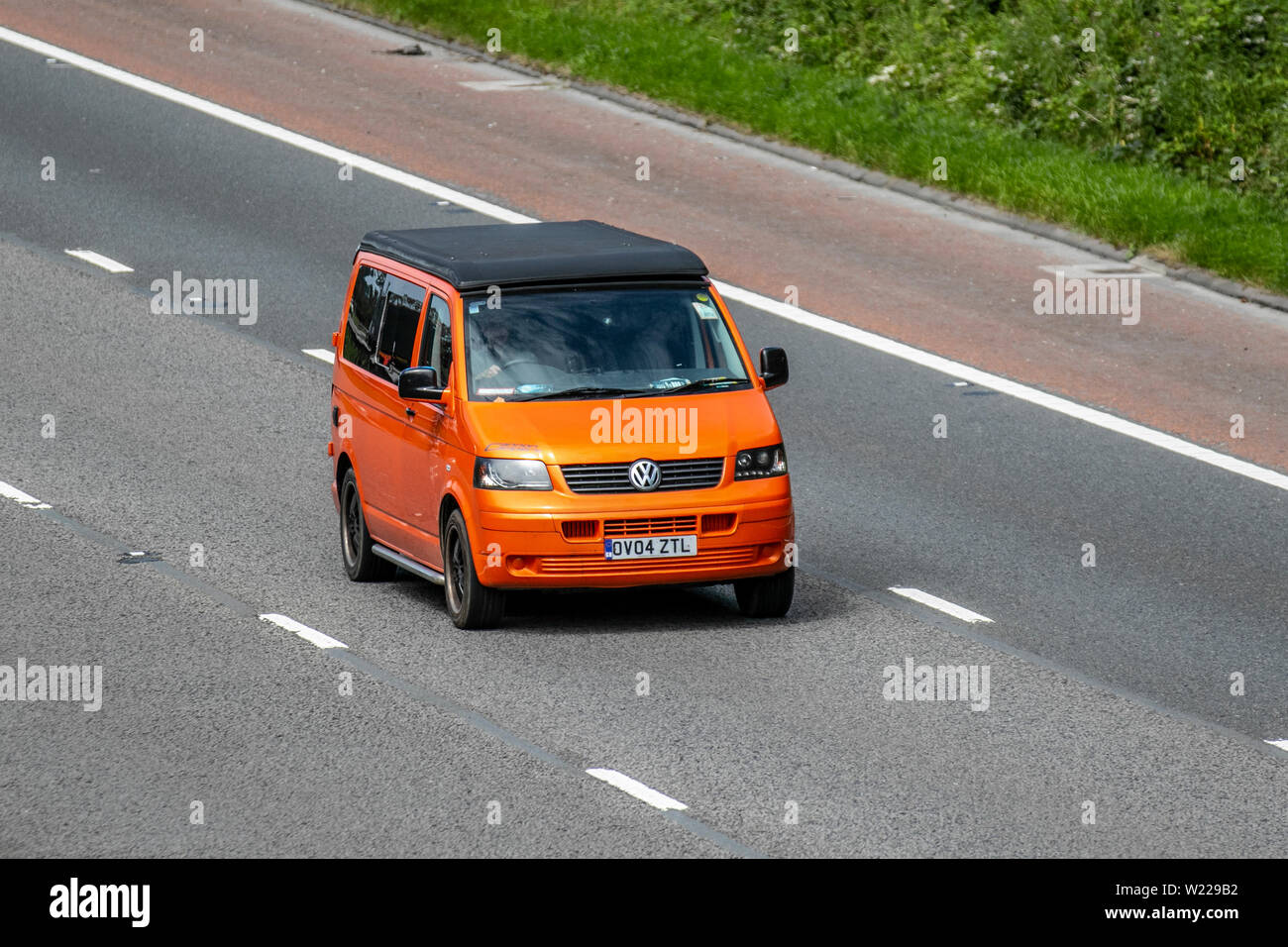 2004 orange VW Volkswagen transporter T30 104 TDI ; M6, Lancaster, Royaume-Uni ; circulation automobile, transport, moderne, en direction du nord sur l'autoroute à 3 voies. Banque D'Images