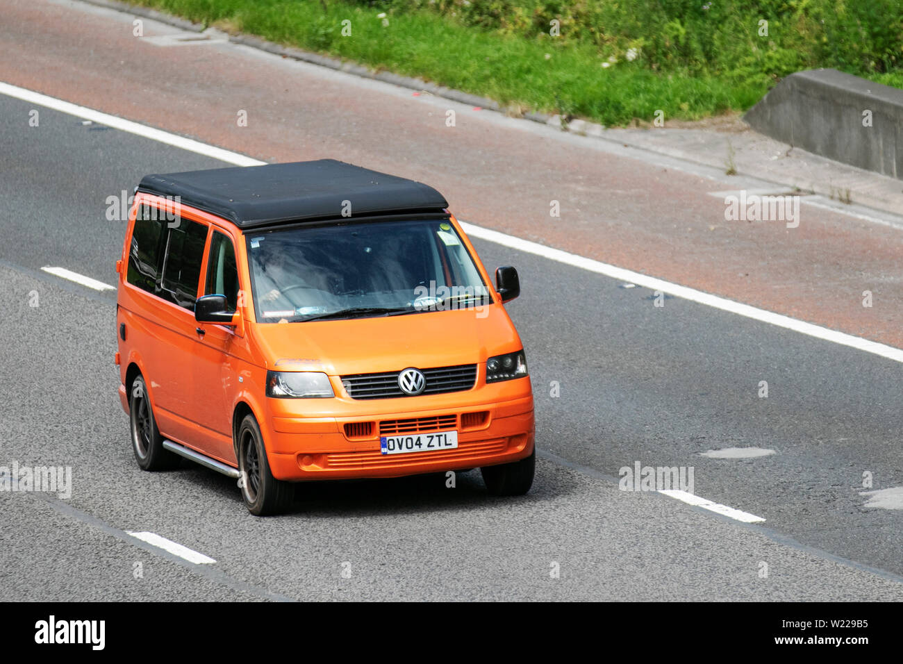 2004 Volkswagen Transporter VW orange T30 TDI 104 ; M6, Lancaster, Royaume-Uni ; le trafic de véhicules, transports, voitures, moderne, vers le nord sur l'autoroute highway 3 lane. Banque D'Images