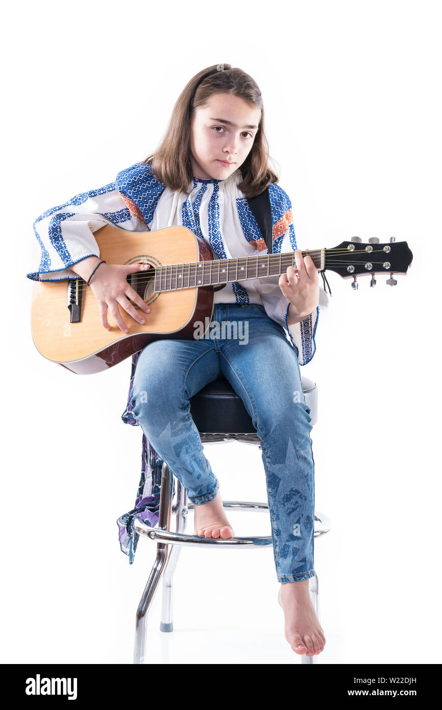 Preteen girl jouer sa guitare isolé sur un fond blanc. Banque D'Images