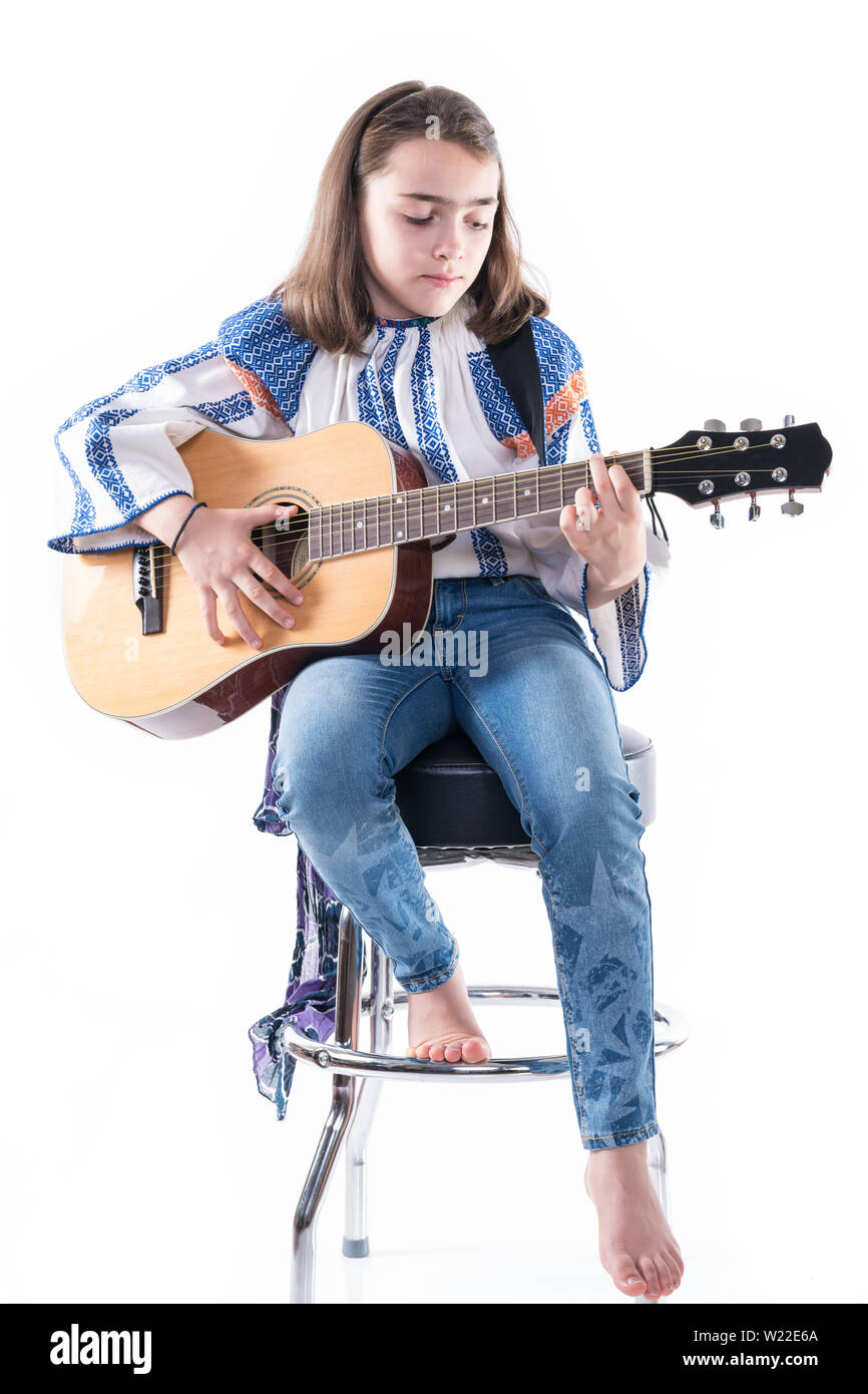 Preteen girl jouer sa guitare isolé sur un fond blanc. Banque D'Images