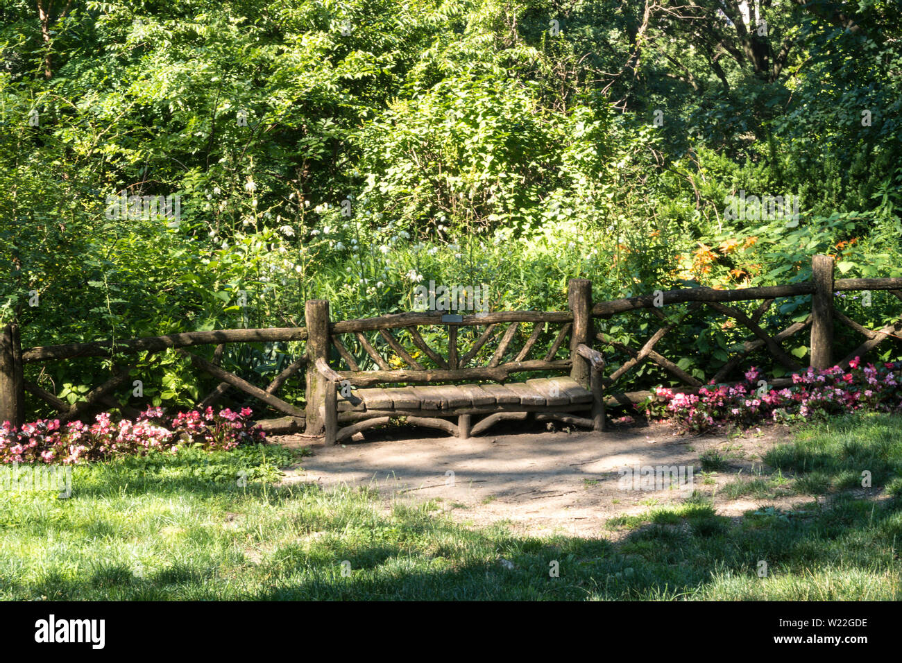 Banc en bois naturel et rustique en clôture , Shakespeare Graden, Central Park, NYC, USA Banque D'Images
