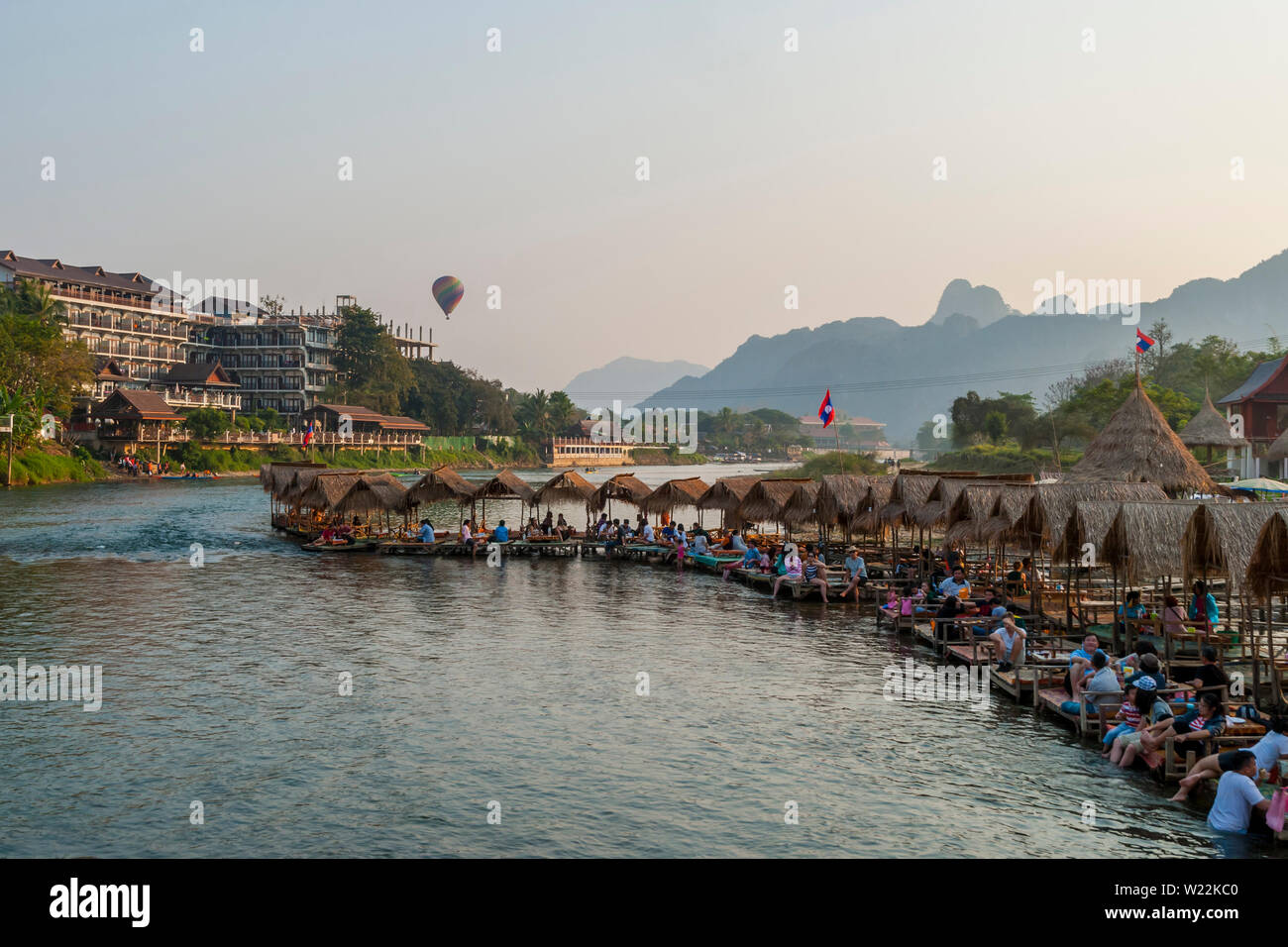 Vang Vieng, Laos - Dec 2016 : les personnes bénéficiant au bar flottant sur la rivière à Vang Vieng et vol en montgolfière au-dessus de la ville Banque D'Images