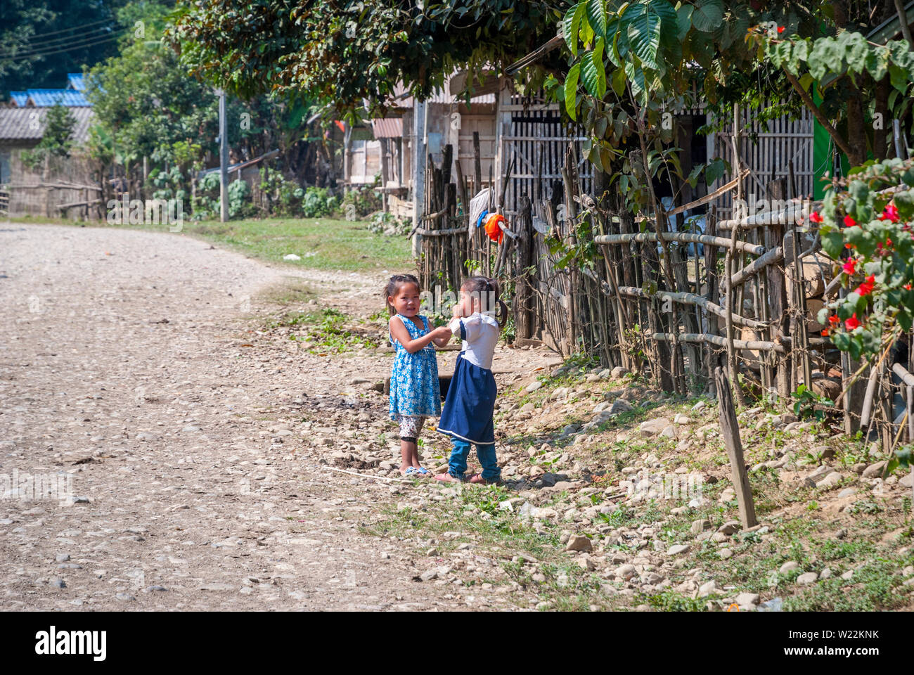 Vang Vieng, Laos - Dec 2016 : Deux filles qui jouent près de la route, à l'extérieur du village de Vang Vieng Banque D'Images