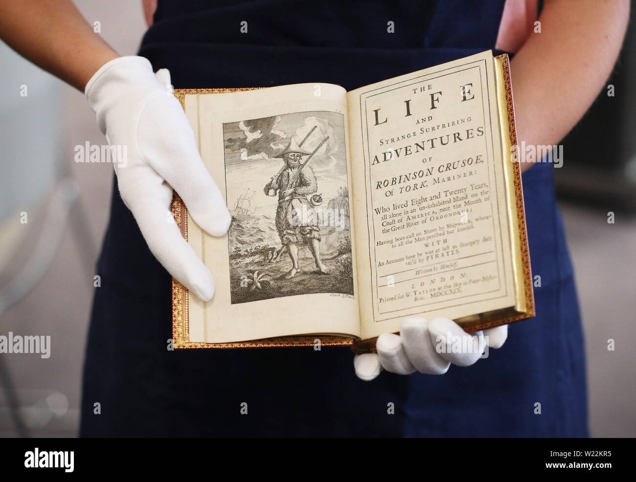 Un employé de Sotheby's gère une première édition de "Robinson Crusoe" de Daniel Defoe qui sera inclus dans Sotheby's upcoming littérature anglaise, l'histoire, livres pour enfants, et les illustrations aux enchères. Banque D'Images