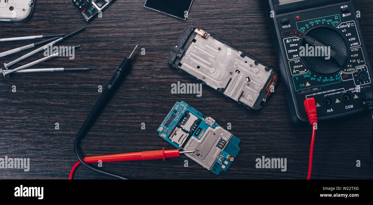 Téléphone mobile démonté et outils sur fond de bois Banque D'Images