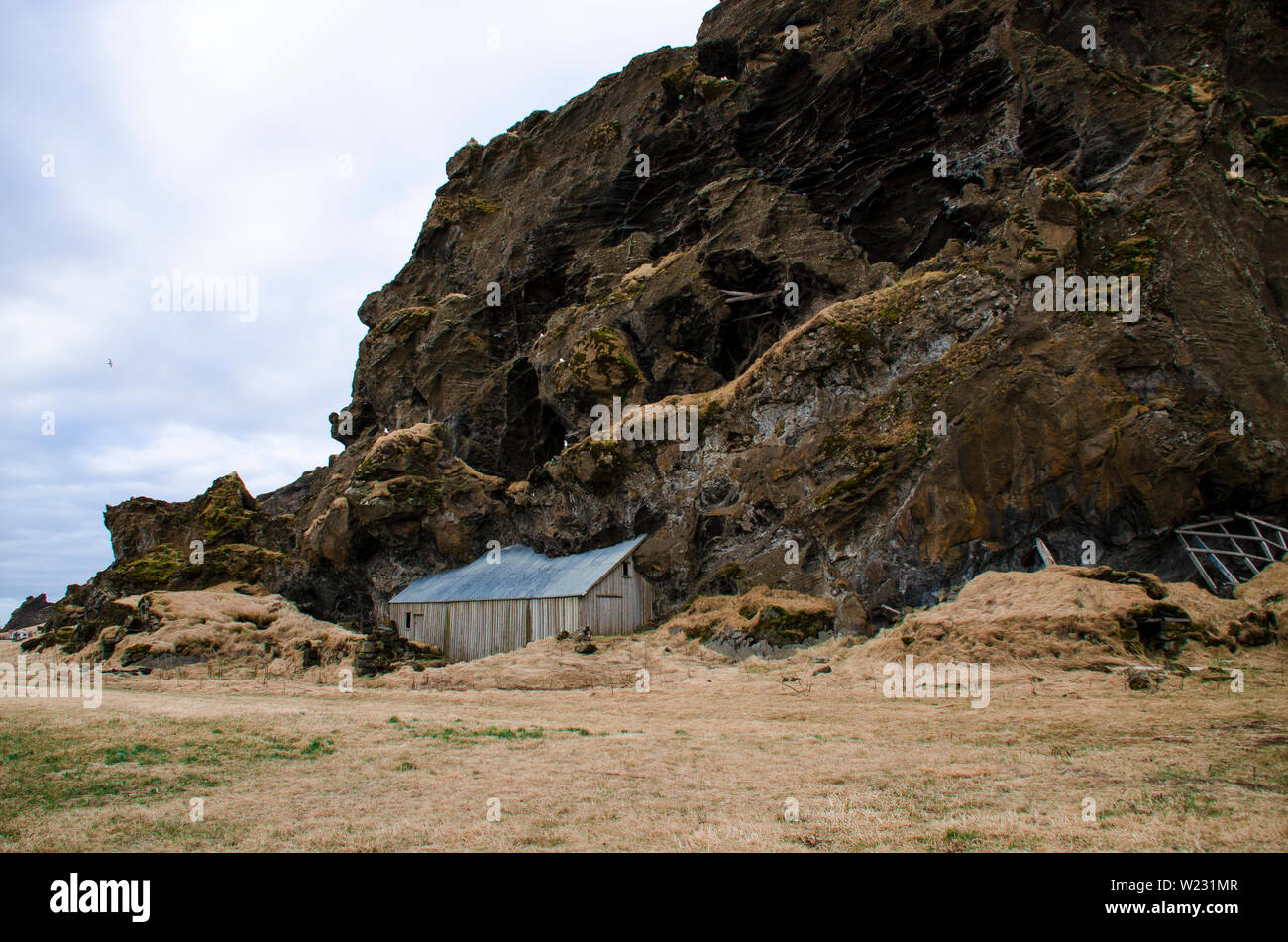 Paysage scandinave. Vieille maison en pierre antique détruit recouvert d'herbe sèche jaune en Islande Banque D'Images