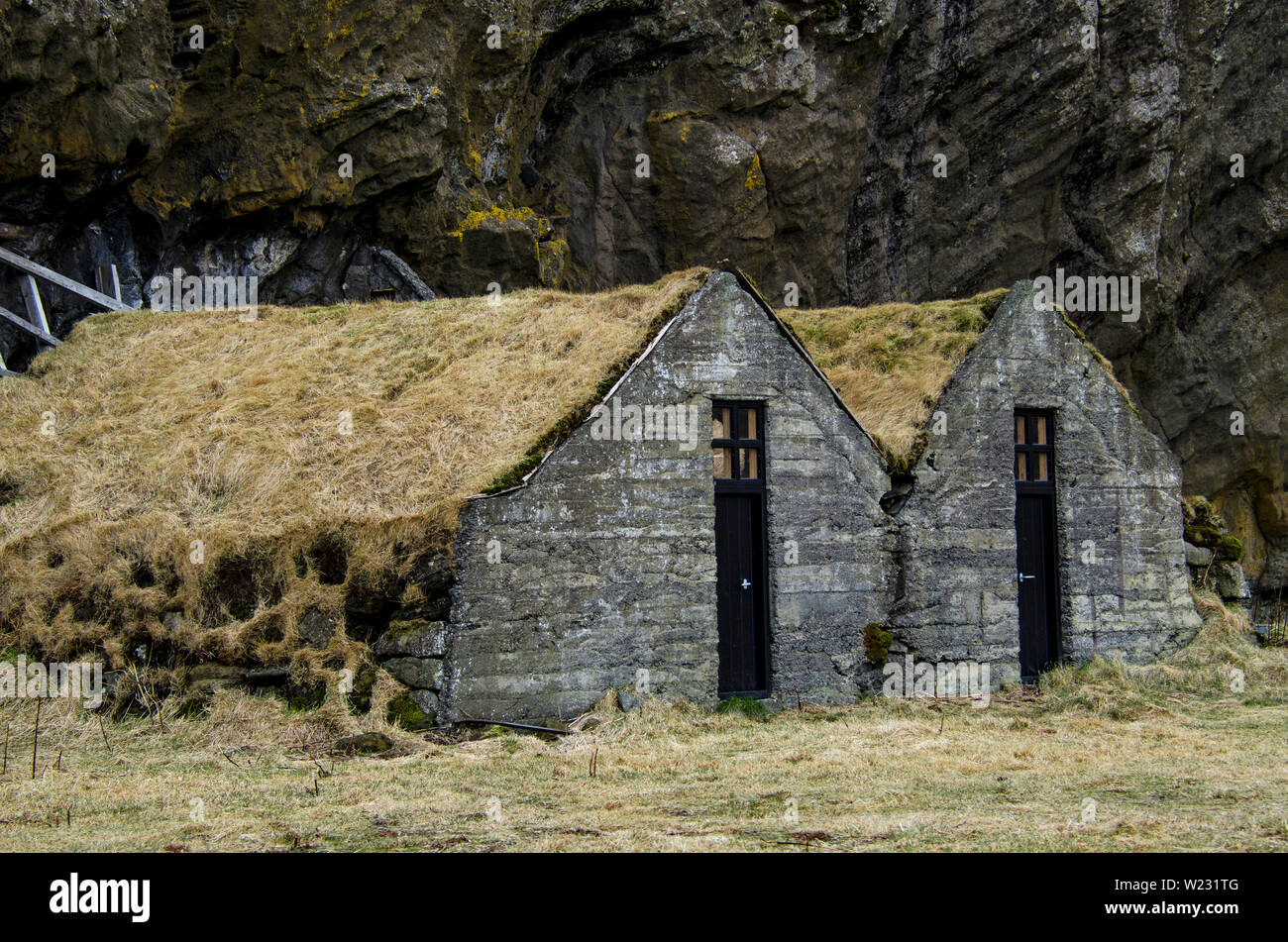 Paysage scandinave. Vieille maison en pierre antique détruit recouvert d'herbe sèche jaune en Islande Banque D'Images